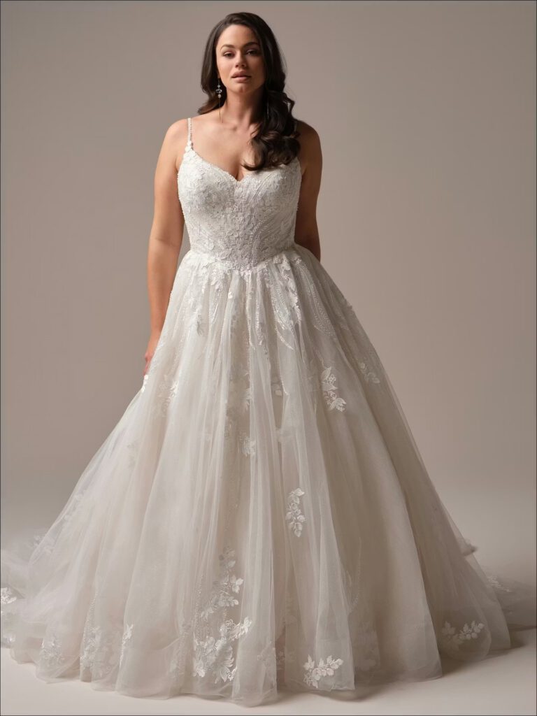 a plus-size elegant bride wearing a romantic wedding dress with beading and lace.