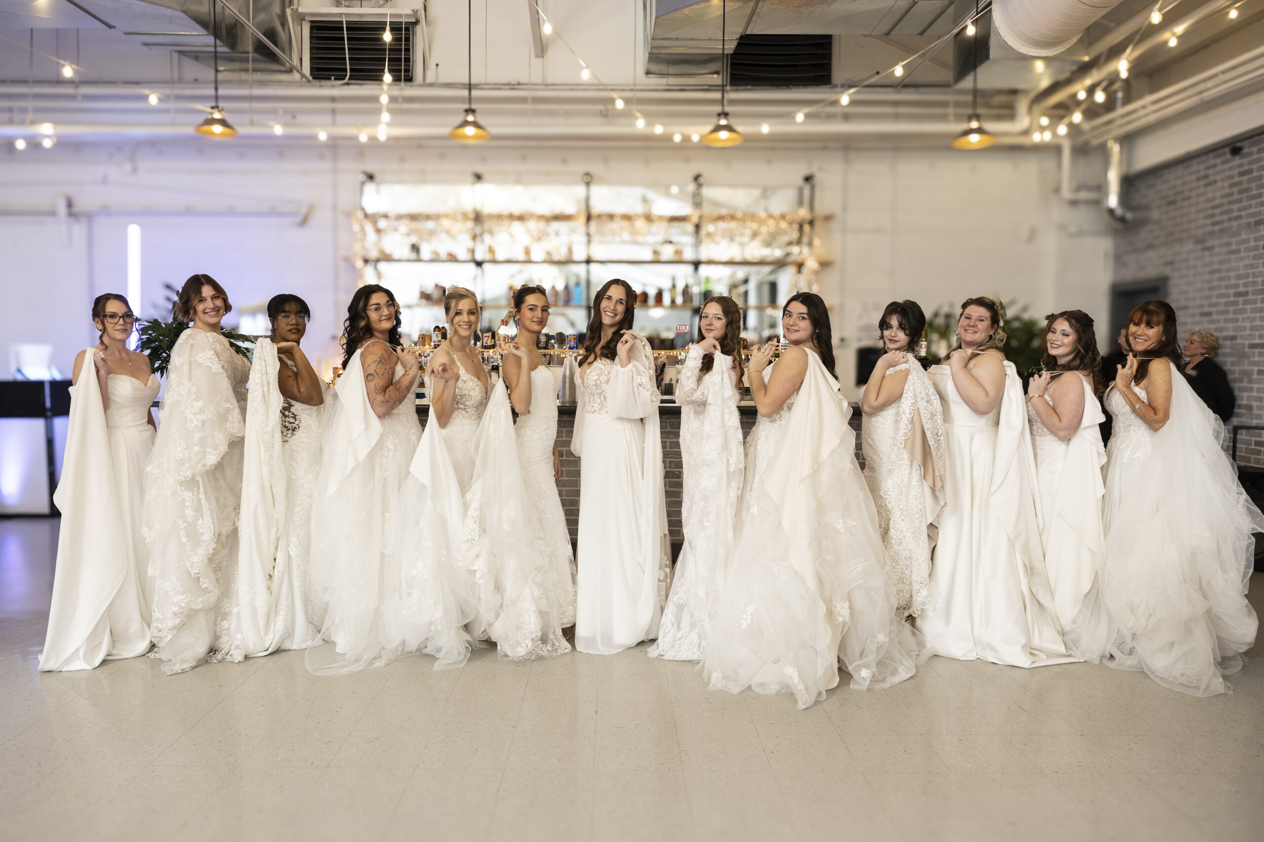 A group of elegant brides showing the trains of their wedding dresses.