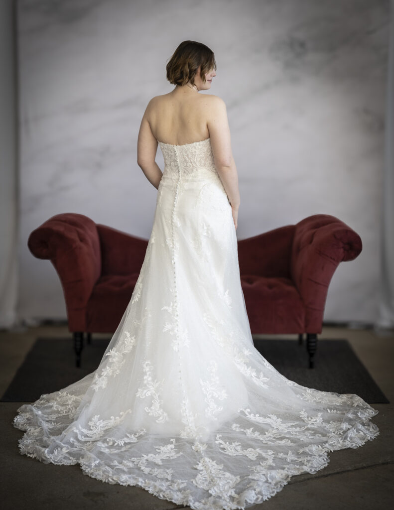 Maggie Sottero's Kyler from the back perspective, showing its train with beautiful lace appliques.