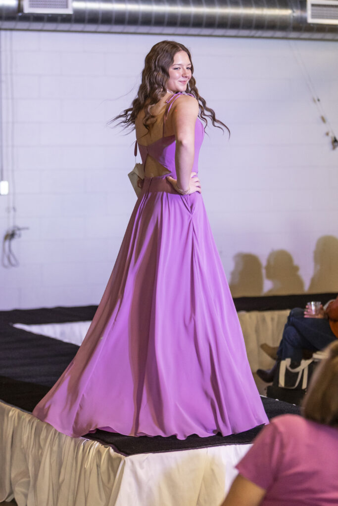 An Elegant Brides model wearing a pinkish purple Morilee bridesmaid dress.