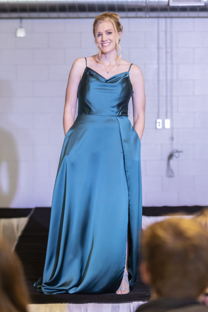 A model wearing a blue morilee bridesmaid dress from Elegant brides.