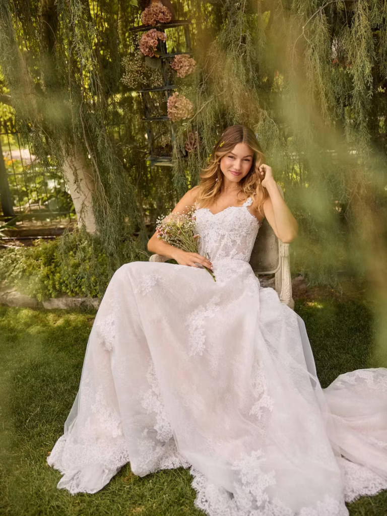 A romantic Rebecca Ingram wedding dress featuring playful details, a full skirt and an A-line silhouette.