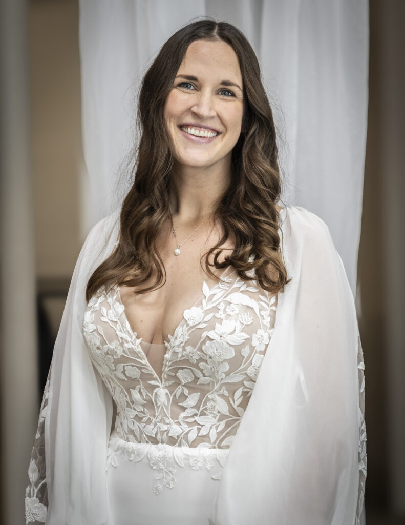 An elegant bride wearing a boho wedding dress with sleeves and a lace covered bust, Sue by Rebecca Ingram.
