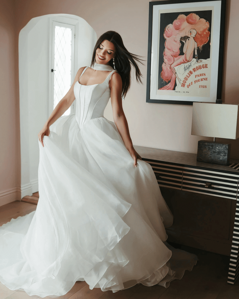 A modern Stella York wedding dress that combines elements of a classic wedding dress with modern trends. The dress features a corset-inspired bodice and a full chiffon skirt.