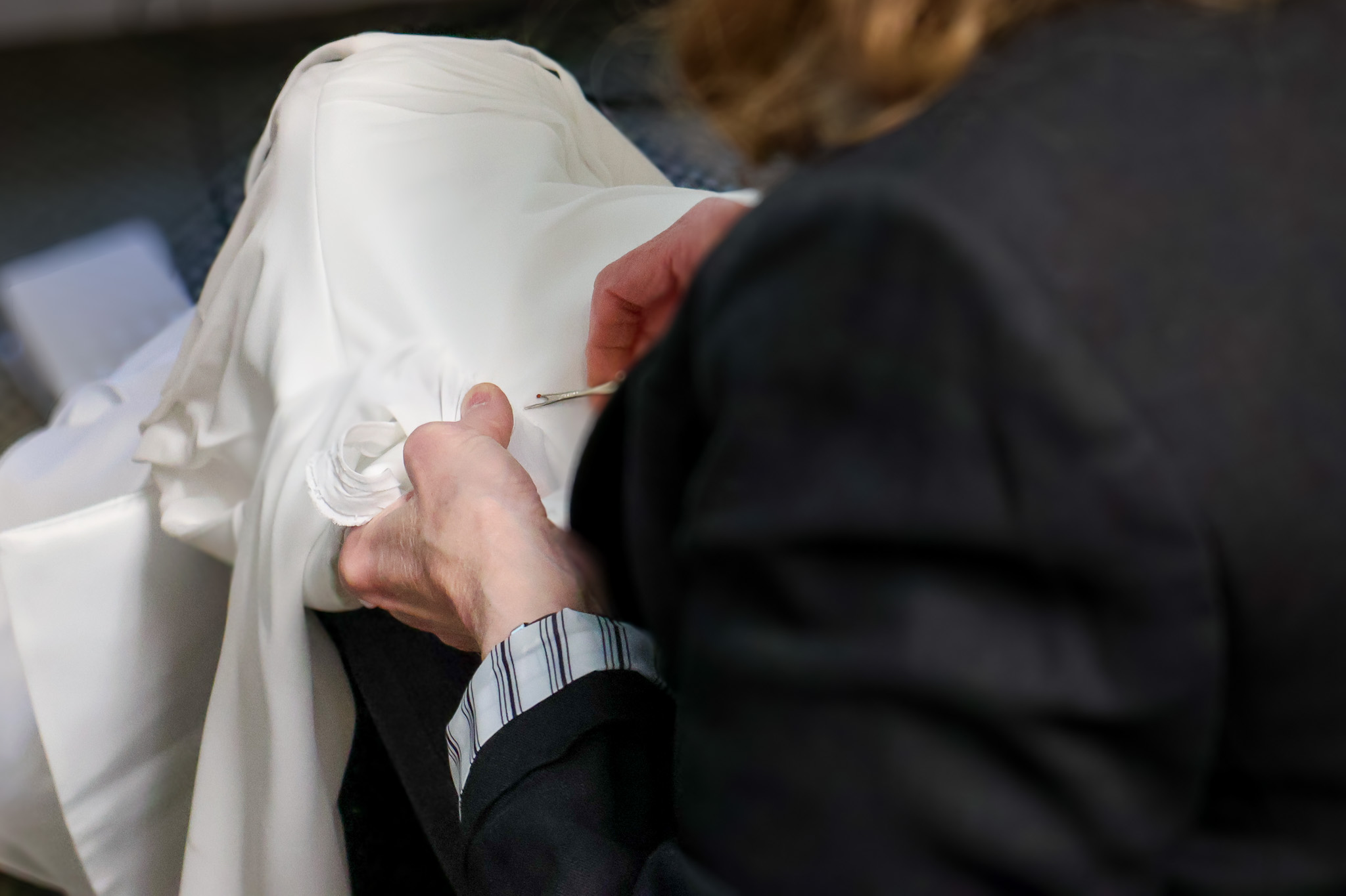 An Elegant Brides Seamstress performing alterations on a wedding dress.