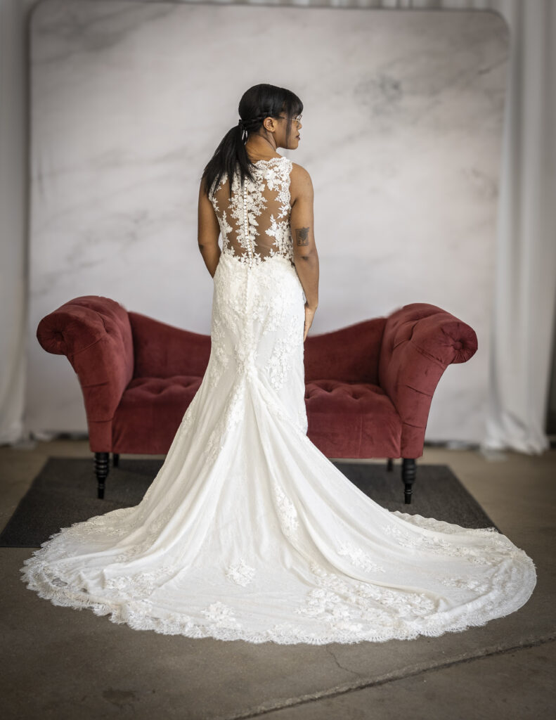 An Elegant Bride wearing Stella York's style 6933, which has elegant lace appliques across an illusion back and a long train.