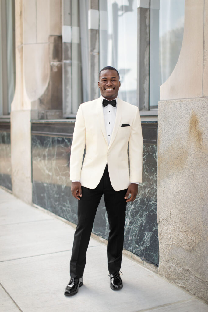A man in a black and white suit for a wedding.